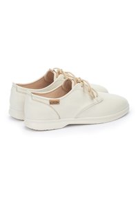 Zapatos de cuero blanco con un acabado suave, punta redondeada, cordones en color beige claro y un forro interior en color marrón. Diseño minimalista con marca.