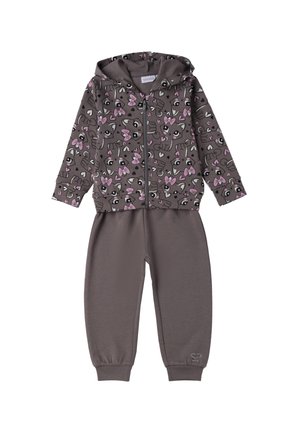 Completo con felpa zip-up e pantaloni grigi con una vivace stampa animale rosa. Realizzato in tessuto morbido, presenta polsini a coste e un cappuccio foderato.