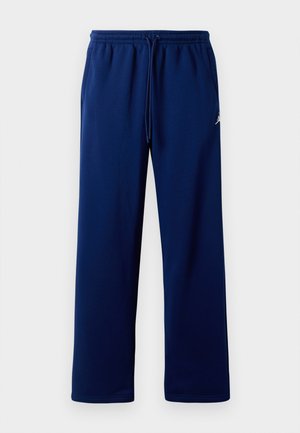 Pantaloni da tuta blu navy con vita elasticizzata e cordoncino. Presentano una texture liscia e un piccolo logo sul lato sinistro.