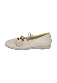 Zapato plano de color beige claro, hecho de un material texturizado, con un acento floral y una piedra brillante. Punta cerrada con una suela flexible.