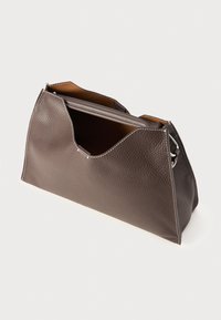 Brown leather handbag with textured surface, triangular shape, and contrasting white stitching along the edges. Open top design.