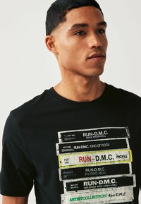 Next LICENSE REGULAR - Nyomott mintás póló - black run dmc