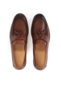 Mocasines de cuero marrón con detalle de borlas, acentos cosidos, punta redondeada y plantilla acolchada. Diseño conciso y clásico.