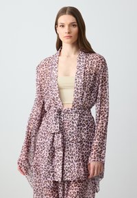 Kimono leggero e trasparente in rosa con una fantasia leopardata. Presenta maniche lunghe e una vita legata, offrendo un design a scollo aperto.