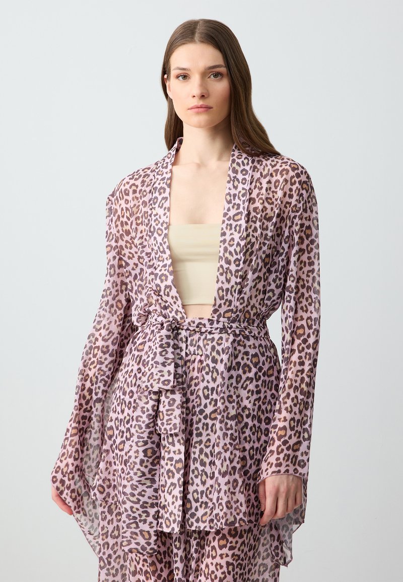 Kimono leggero e trasparente in rosa con una fantasia leopardata. Presenta maniche lunghe e una vita legata, offrendo un design a scollo aperto.