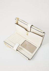 White leather wallet, zippered closure, gold-tone hardware, multiple card slots, transparent ID pocket, smooth texture, and a minimalist design.