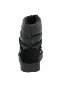 Bottine noire rembourrée à la cheville avec un extérieur lisse, des accents en daim texturé et une semelle en caoutchouc plate ; présentant un tige haute et des sangles ajustables.