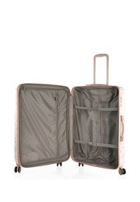 Maleta rígida en rosa claro con detalles en blanco. El interior cuenta con un forro gris, un bolsillo con cremallera y correas ajustables para organizar.