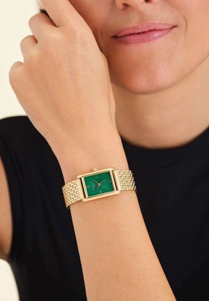 Reloj rectangular dorado con esfera verde y correa de malla dorada, que muestra marcadores de hora minimalistas y una pequeña corona en la parte superior.