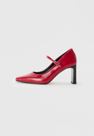 Mary Jane rosso con punta a punta, tacco alto e una sola fascia con fibbia argentata su uno sfondo bianco semplice.