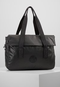 Sac cabas noir en matière souple avec deux sangles texturées, une fermeture à rabat et un logo rond sur le devant. Comprend une poche latérale zippée.