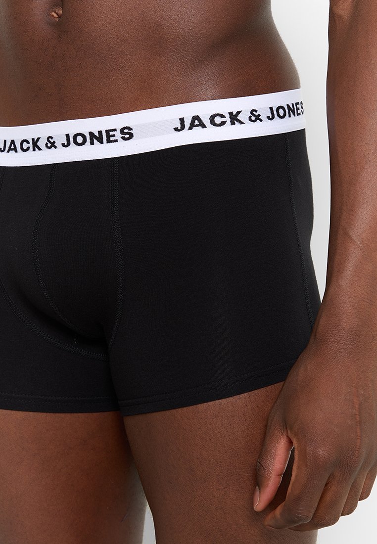 Schwarze Boxershorts aus weichem Stoff mit einem weißen elastischen Bund, auf dem "JACK & JONES" in schwarzer Schrift steht. Eng anliegendes Design.