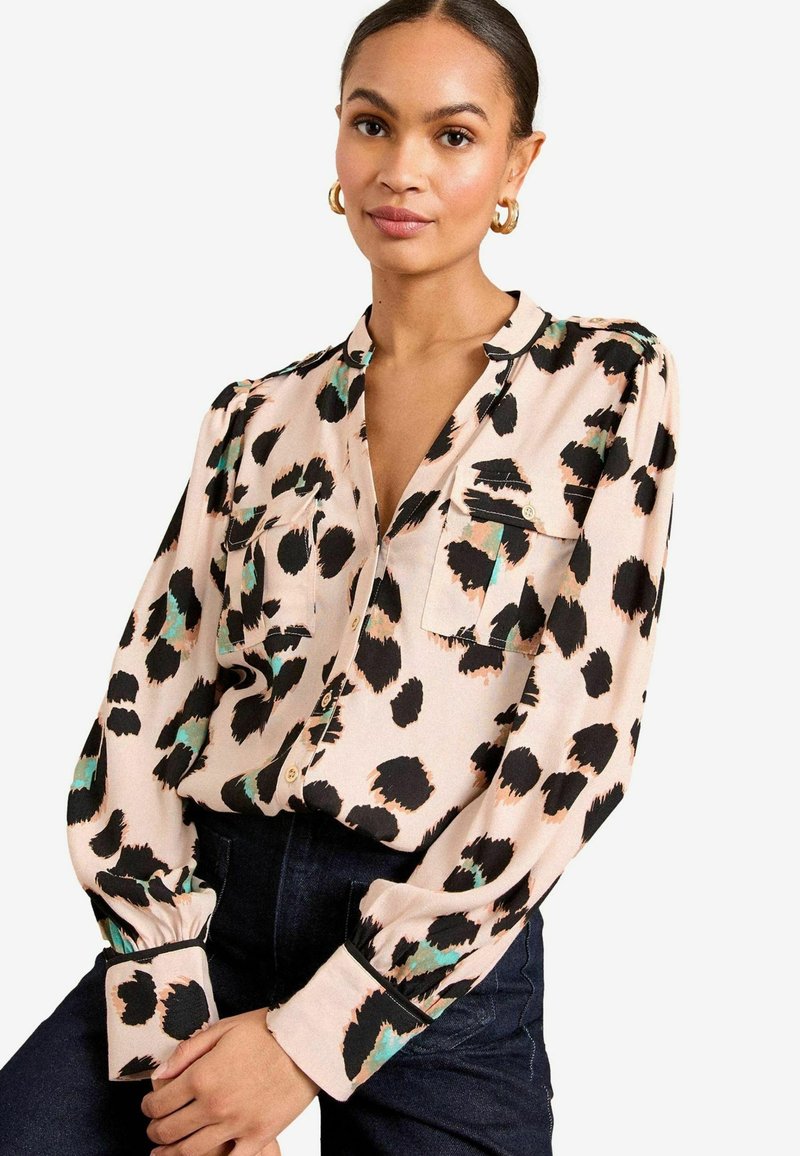 Blusa a stampa animalier in tessuto morbido, con motivi neri, verdi e pesca, chiusura con bottoni frontale, tasche sul petto e maniche lunghe con polsini.