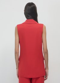 Roter ärmelloser Blazer mit Reverskragen und taillierter Passform. Glatter Stoff, gerader Saum und seitliche Taschen Details.