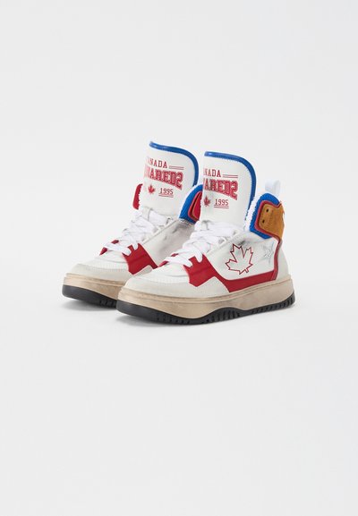 Zapatillas altas con parte superior de cuero blanco, detalles en rojo y cuello azul. Presentan un logo de hoja de arce y un detalle de texto retro; suela texturizada.