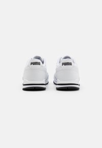 Valkoiset Puma-tennarit, joissa on sileä nahkainen päällinen, mustat yksityiskohdat kantapäässä ja pohjassa, sekä pehmustettu nilkka ja kieli mukavuutta varten.