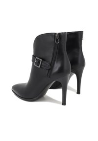 Botines de cuero negro con punta puntiaguda, tacón alto, cremallera lateral y un detalle de hebilla en la correa sobre el tobillo.