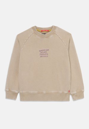 Sweatshirt bege com mangas raglan, decote redondo e um corte ligeiramente cropped. Apresenta texto bordado no peito e logotipo na lateral.