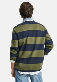 Gestreepte pullover in donker navy en olijfgroen, met een kraag, lange mouwen en een relaxed fit. Katoenen materiaal met een zachte textuur.