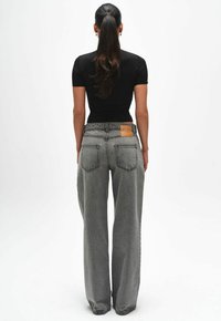 Grijze jeans met een wijd been en een textuurafwerking, voorzien van een leren patch op de achterkant van de taille en twee achterzakken.