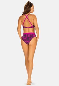 Fioletowy i różowy bikini z wzorem, z krzyżującymi się paskami na plecach i wysoko osadzonymi majtkami, charakteryzujące się gładką strukturą i odważnym abstrakcyjnym wzorem.