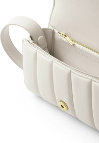 Borsa a mano in pelle trapuntata di colore crema con tasca con zip e hardware dorato. Presenta un manico superiore e una fodera interna morbida.