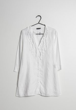 Camicia di lino bianca con maniche a tre quarti, caratterizzata da dettagli arricciati lungo il neckline e chiusura con bottoni sulla parte anteriore.
