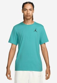 T-shirt azzurro a maniche corte realizzato in cotone, con il logo Jumpman nero sul lato sinistro del petto. Design classico con collo girocollo.