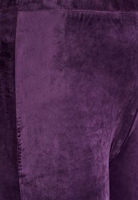 Purppura pehmeä kangas, jossa on sileä pinta ja hienovarainen kiilto, sekä sivusaumadetaili, joka parantaa suunnittelua.