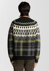 Πουλόβερ από μαλλί με γεωμετρικό σχέδιο σε μαύρο, λευκό, γκρι και κίτρινο, με στρογγυλή λαιμόκοψη και ριμπ μανσέτες και τελείωμα.