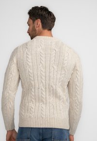 Cremfarbener Sweatpullover mit Kabelstrickmuster, strukturiertem Design, gerippten Bündchen und Saum, klassischem Rundhalsausschnitt und weicher, gewebter Optik.
