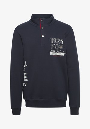 Jūras spēku džemperis ar augstu apkakli, ar pogu klāstu, izšūtām dizaina detaļām un kontrastējošiem sarkaniem akcentiem. Mīksta auduma ar ribotām piedurknēm.