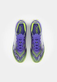 Scarpe da calcio sintetiche viola con dettagli verde lime, dotate di una tomaia texture, allacciatura centrale e un logo "F50" ben visibile.