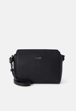Sac bandoulière rectangulaire noir avec sangle ajustable et logo ainsi que des éléments métalliques dorés sur fond blanc.