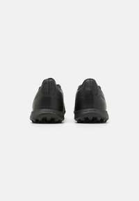 Baskets de sport noires avec un dessus en cuir texturé, profil bas et une semelle en caoutchouc robuste pour une meilleure adhérence. Design minimaliste avec lacets.