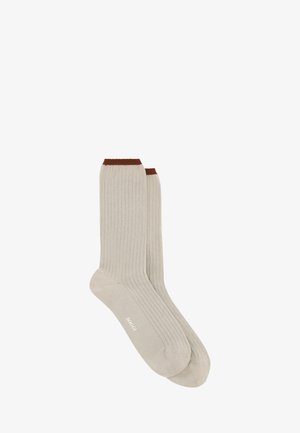 Chaussettes mi-mollet côtelées beige clair avec bordures marron foncé et logo blanc "HOGGI" sur le pied.