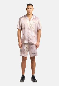 Satin kortærmet skjorte og matchende shorts i lys mauve med blomsterprint. Får det "Carlo Gucci" logo og en afslappet pasform.