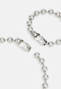Silver-toned necklace featuring round metallic beads and a clasp design, showcasing a smooth, polished texture and a uniform geometric shape.