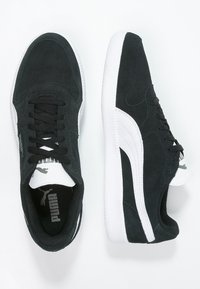 Schwarze Wildledersneaker mit weißen Gummisohlen. Seitliches Logo und Schnürsenkel in Schwarz, kontrastierendes weißes Streifenmuster an den Seiten.