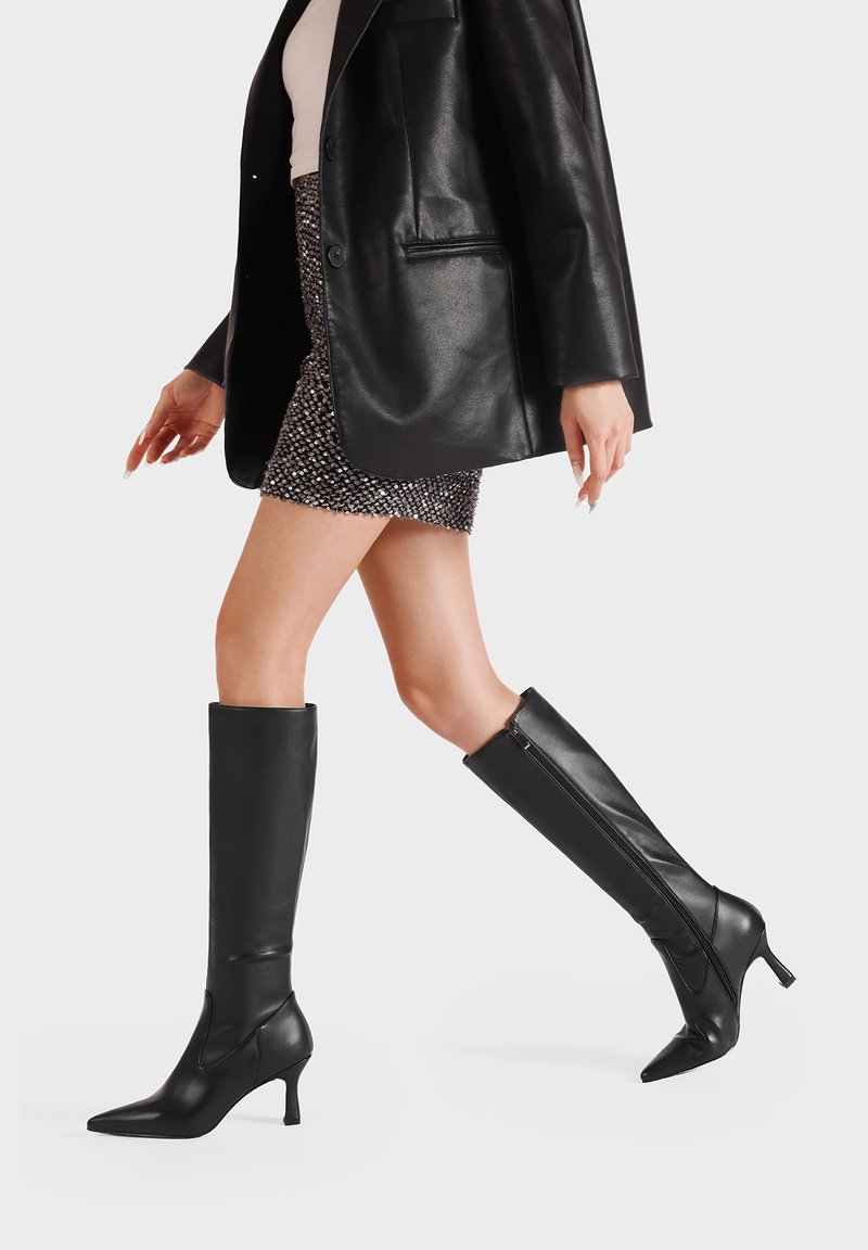 Stivali neri al ginocchio con punta affusolata e design elegante. Realizzati in pelle liscia e dotati di una zip laterale per una facile vestibilità.