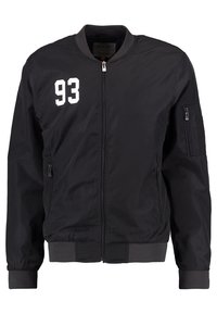 Schwarze Bomberjacke mit Reißverschluss, gerippten Bündchen und Saum, mit weißen "93" auf der linken Brust und einer Reißverschlusstasche am Arm.