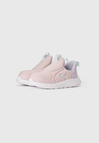 Baskets à enfiler pour enfant avec des tiges en tissu rose pâle et lavande, des semelles blanches et le logo Puma sur le côté.