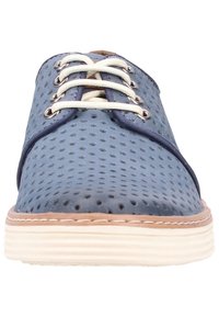 Chaussures en cuir bleu perforé avec des lacets beige et une semelle en caoutchouc crème. Elles présentent un bout arrondi et des coutures contrastantes le long du bord.