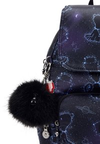 Marinblå ryggsäck med stjärn- och planetsynmönster, svart fluffig pom-pom nyckelring och en röd husformad charm fäst vid dragkedjan.