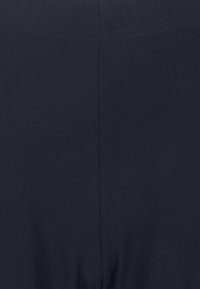 Dunkelblauer Stoff, glatte Textur, tailliertes Design mit einem subtilen Glanz. Verfügt über saubere Nähte entlang der Säume. Keine sichtbaren Muster oder Akzente.