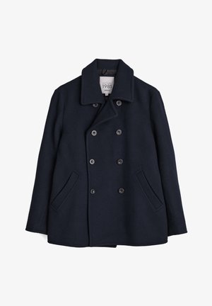 Palton de lână bleumarin închis cu închidere cu nasturi dubli, guler lat și buzunare laterale. Textură netedă, formă ajustată, accente minime.