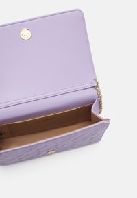 Lila kviltad axelväska med guldkedjestraps, magnetlås och tanfärgad innerficka märkt "LOVE MOSCHINO."