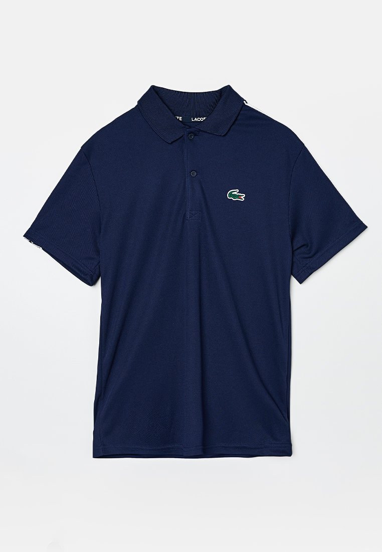 Dunkelblaues Poloshirt aus strukturiertem Stoff, mit Kragen, einer Zwei-Knopf-Leiste und einem kleinen grünen Krokodil-Logo auf der Brust.