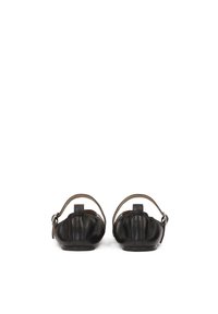 Ballerine in pelle nera con design arricciato, fascetta posteriore regolabile e suole piatte. Presentano un branding discreto sul tallone.