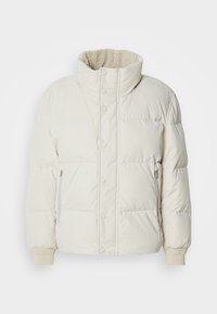 Veste d'hiver matelassée blanc cassé avec col montant, boutons-pression, poches latérales zippées et doublure polaire à l'intérieur du col.
